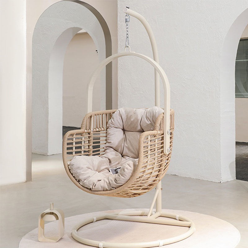 Hanging rattan chair with cushions in a minimalistic room with arches.  | Extraordinary Emporium UK