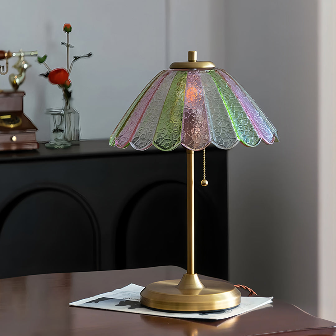 Decorative table lamp with a colorful glass shade on a wooden surface.  | Extraordinary Emporium UK
