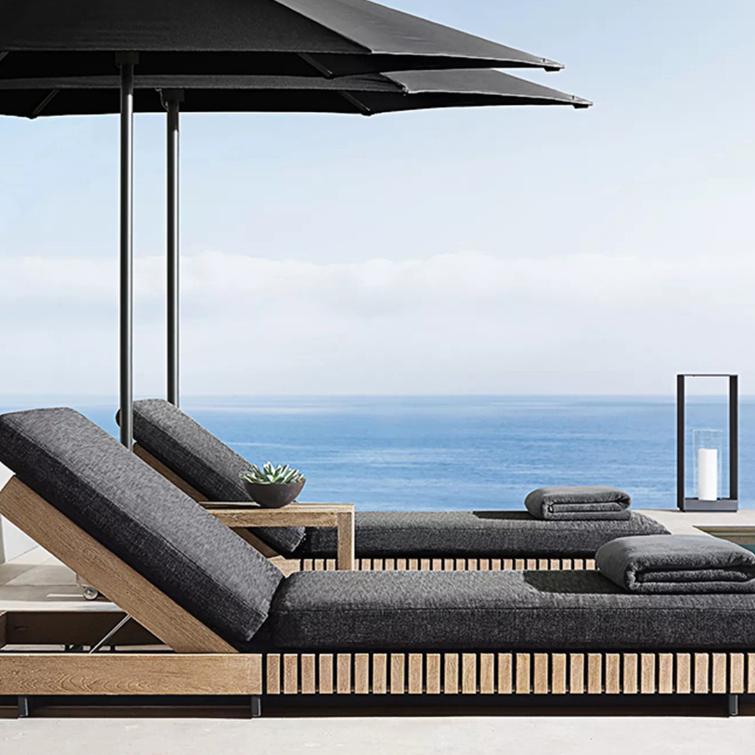 Outdoor lounge chair with umbrella and towels by the ocean  | Extraordinary Emporium UK