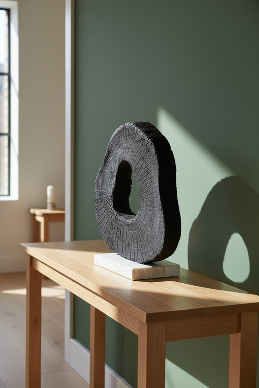 Extraordinary Emporium Artisan Black circular sculpture on a white base 
