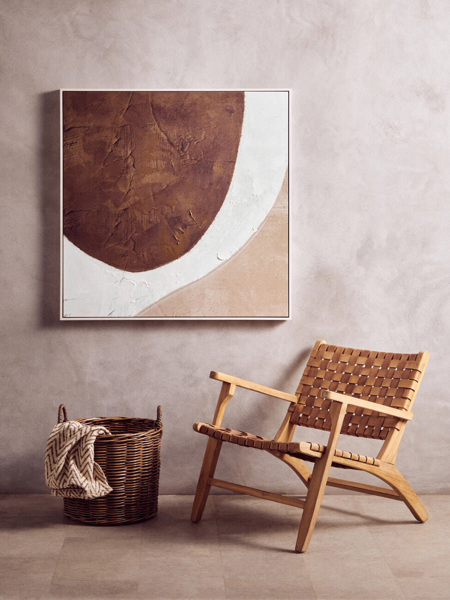 Woven chair and basket against a textured wall with abstract art| Extraordinary Emporium 