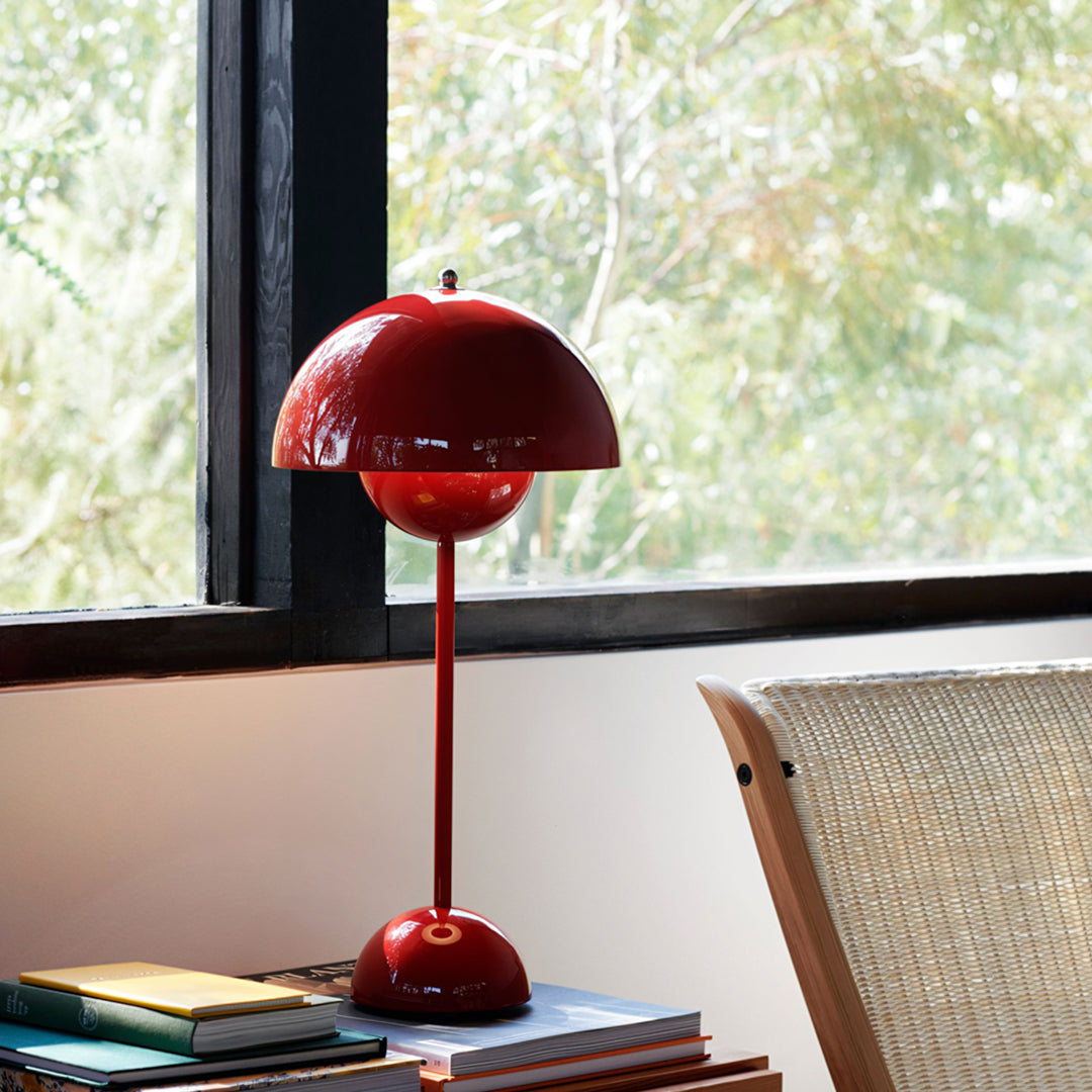 Red table lamp on books with a window in the background | Extraordinary Emporium UK