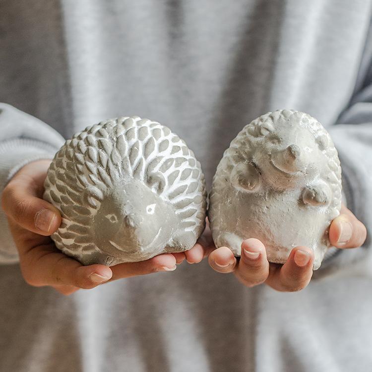 Two stone hedgehog sculptures held in hands against a neutral background  | Extraordinary Emporium UK