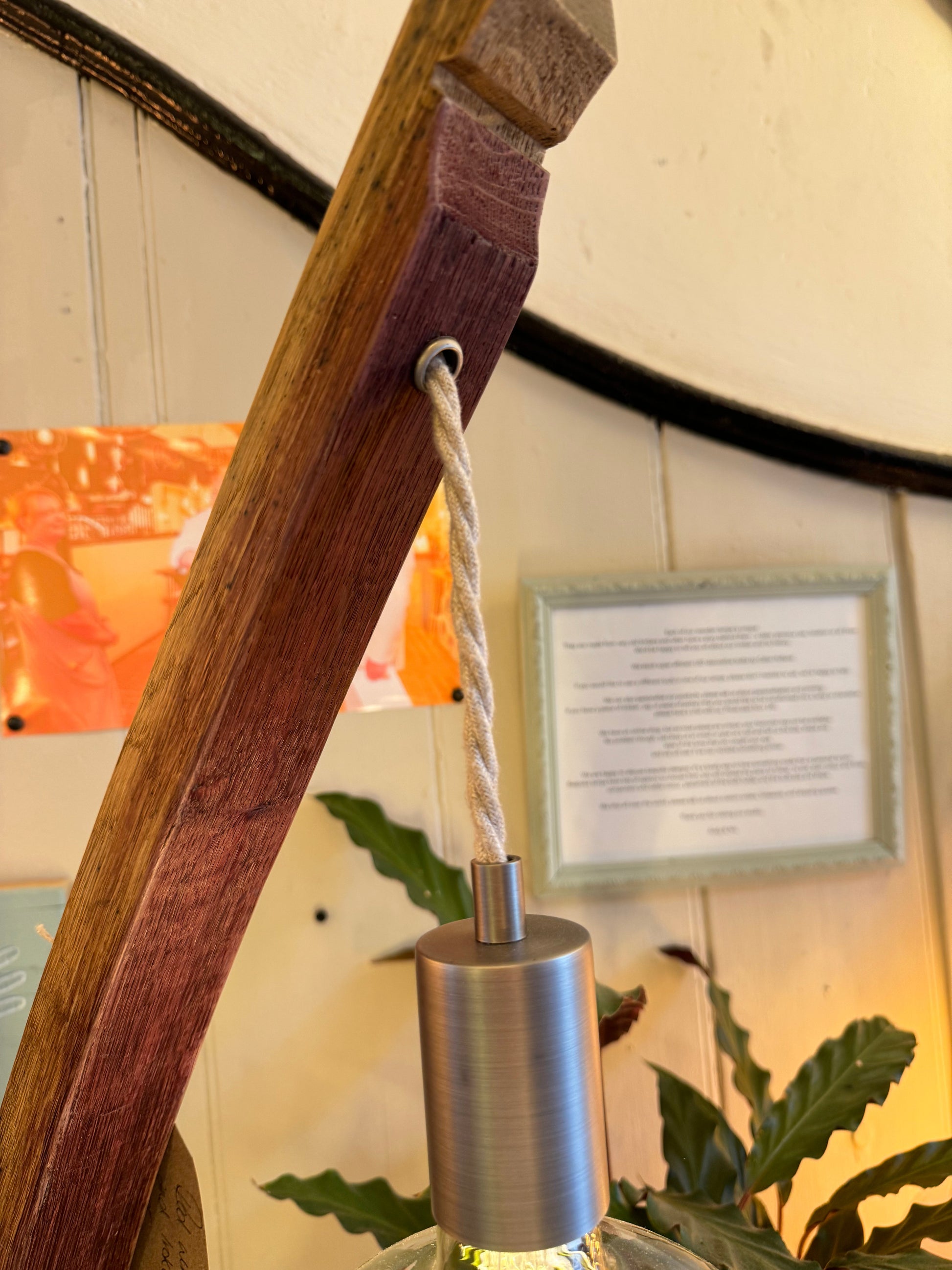 Close-up of a wooden lampshade with a metal fitting and rope, set against a blurred indoor  | Extraordinary Emporium background.