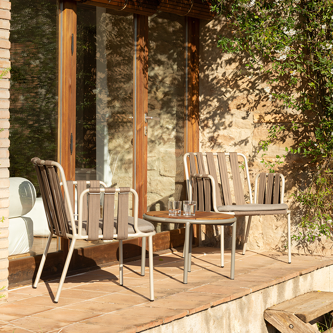 Outdoor seating area with wooden chairs and a small table on a wooden deck.  | Extraordinary Emporium UK