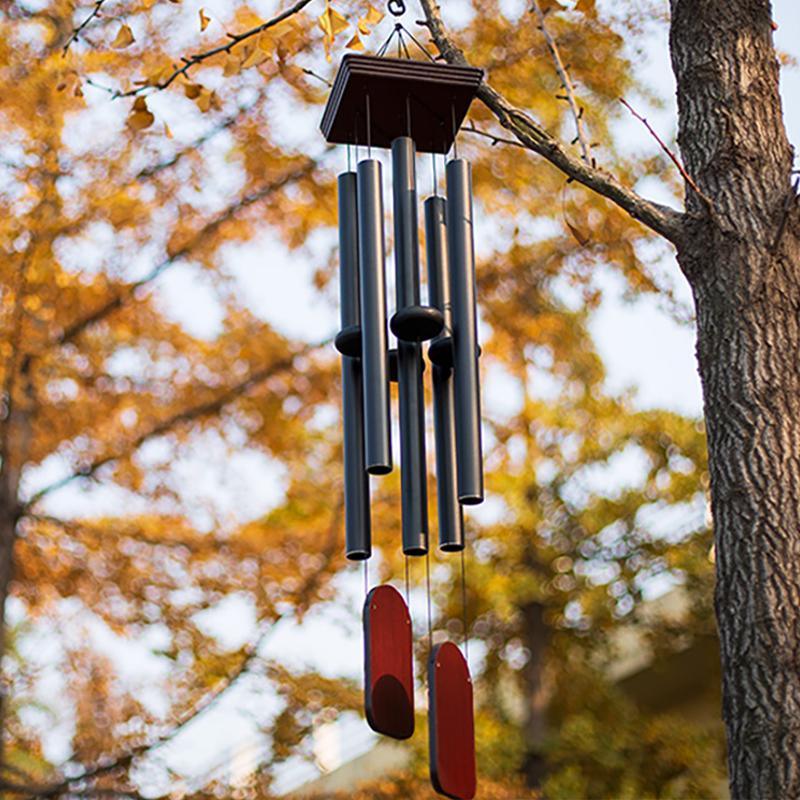 Wind chime hanging from a tree with autumn leaves and snow in the background  | Extraordinary Emporium UK