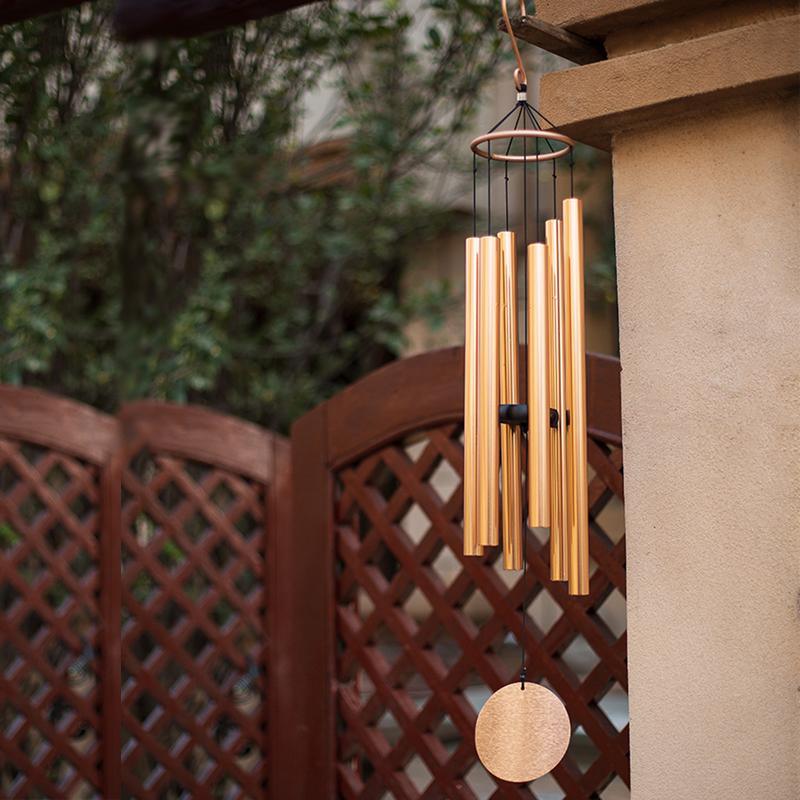 Decorative wind chime hanging on a wall with a garden background  | Extraordinary Emporium UK